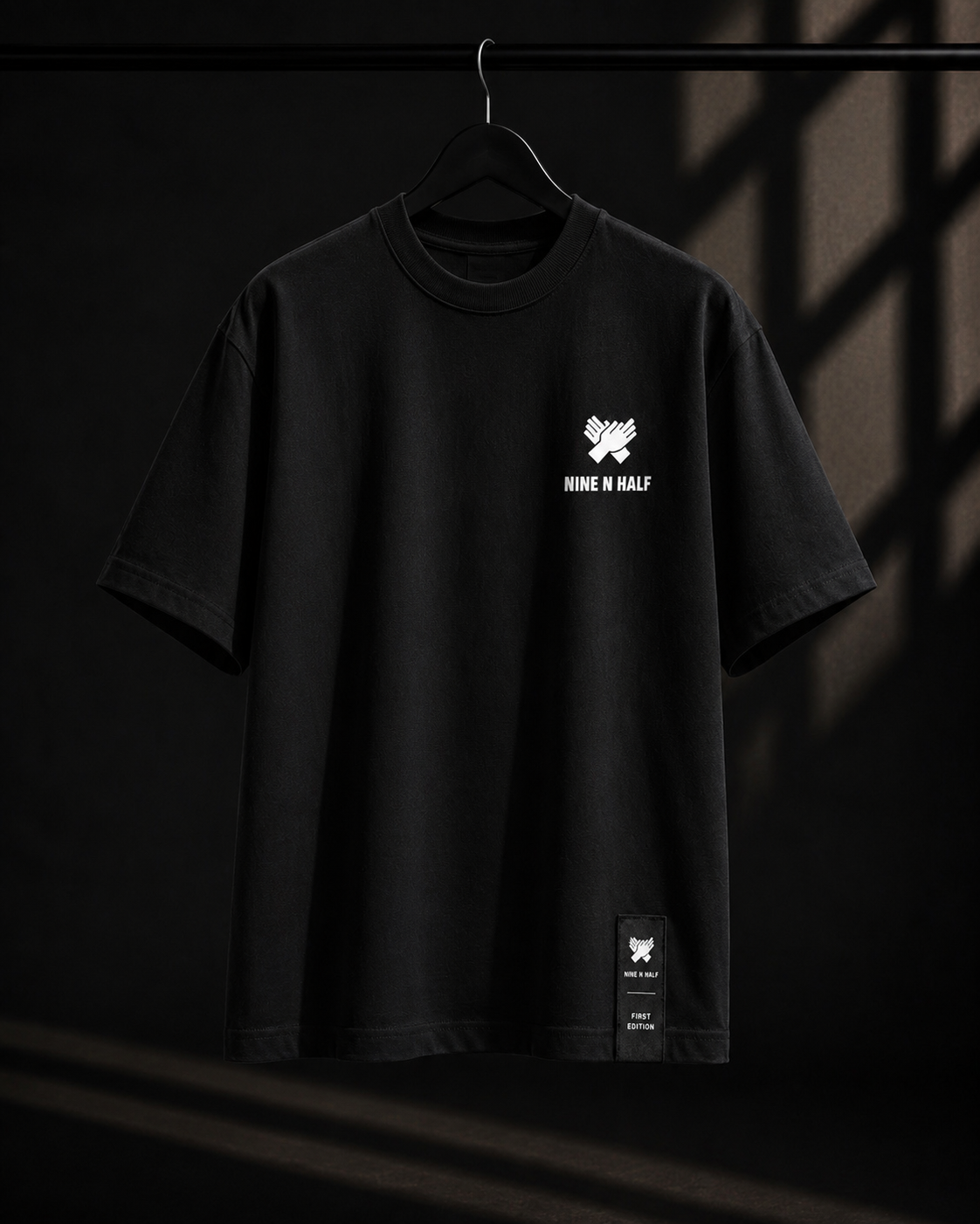     Front view of the Nine N Half First Edition Tee in black color and black hem patch